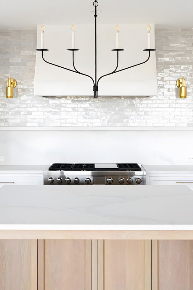 Elegant chandelier with gold metal and crystal droplets above kitchen island