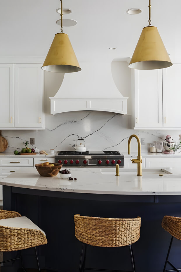 Modern kitchen with white and blue cabinets, marble countertops, and hanging lamps