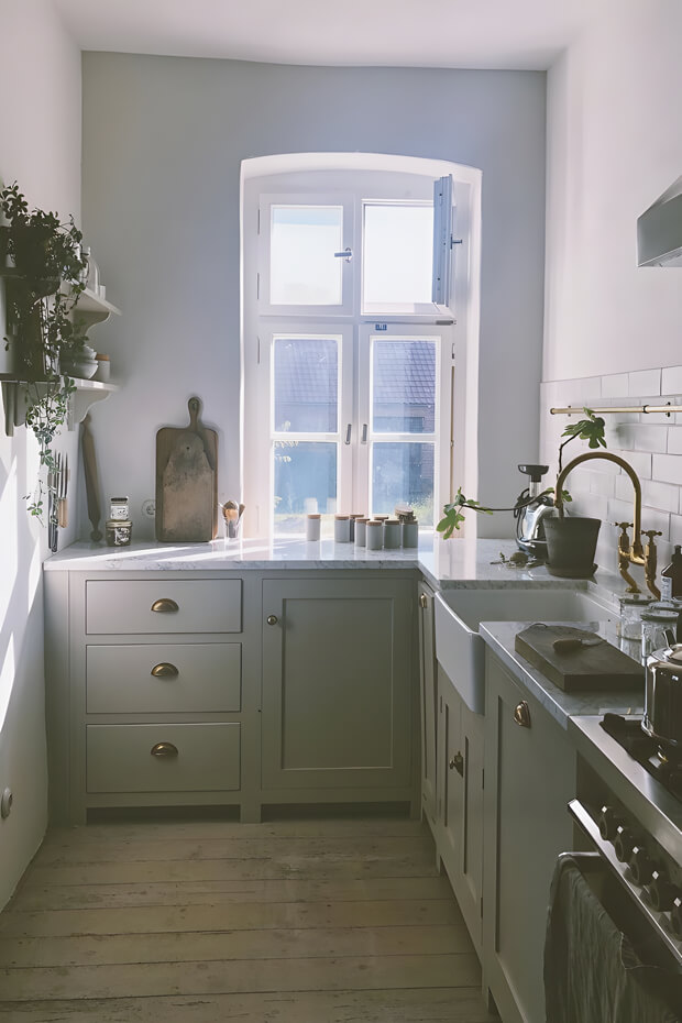 Well-lit countryside kitchen with window over sink