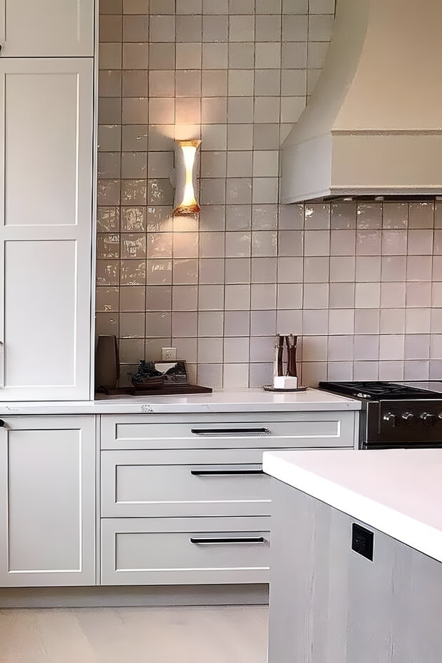 White ceramic herringbone patterned kitchen backsplash tiles with gray grout